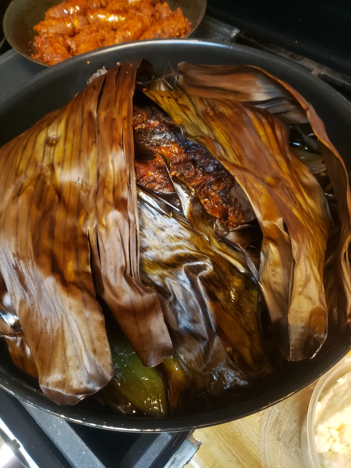 Pork wrapped in banana leaves, roasting in the pot